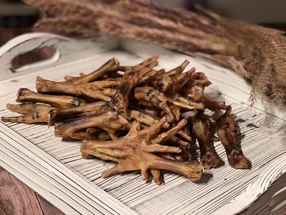 PupChew dehydrated chicken feet for dogs arranged on a white wooden tray