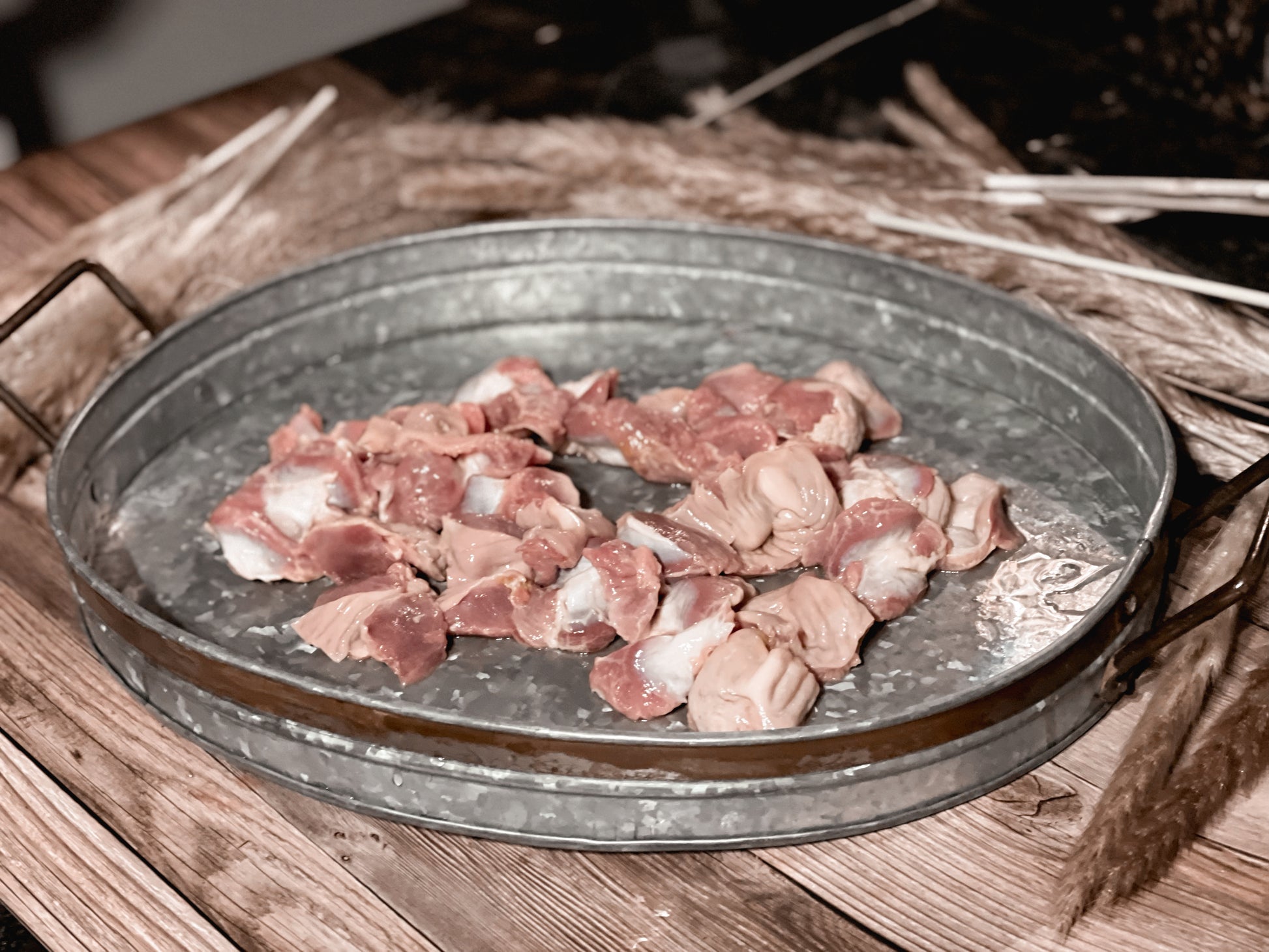 Raw chicken gizzards in a galvanized metal tray before dehydration