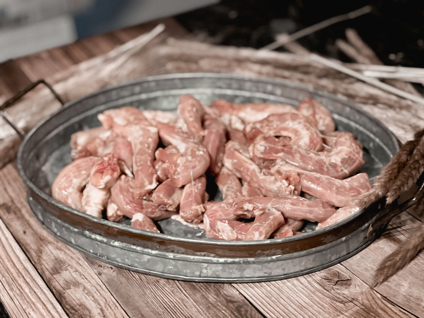 Raw chicken necks in a galvanized metal tray before dehydration